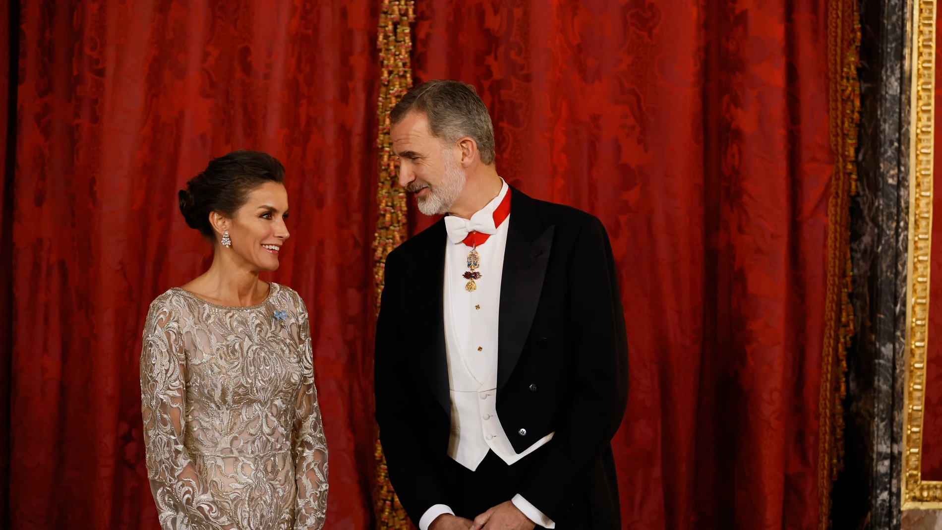 El rey Felipe VI conversa con la reina Letizia (i) a su llegada a la cena de gala ofrecida al emir de Catar, Tamim bin Hamad Al Thani, y su esposa este martes en el Palacio Real, en Madrid.