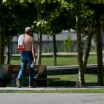 Un hombre camina sin camiseta el día en que España comenzará a sufrir un "importante" episodio cálido con temperaturas de pleno verano. Cézaro De Luca / Europa Press