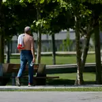 Un hombre camina sin camiseta el día en que España comenzará a sufrir un &quot;importante&quot; episodio cálido con temperaturas de pleno verano. Cézaro De Luca / Europa Press