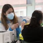 Una mujer recibe la tercera dosis de la vacuna contra el Covid-19, en el WiZink Center, a 20 de enero de 2022, en Madrid
