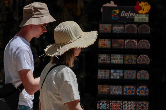 Dos turistas pasean con sombreros para protegerse del calor que impera en la Comunidad