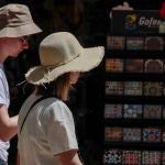 Dos turistas pasean con sombreros para protegerse del calor que impera en la Comunidad
