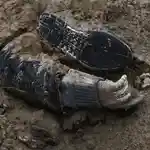 El cuerpo de una persona muerta y enterrada en una fosa común en la ciudad ucraniana de Bucha