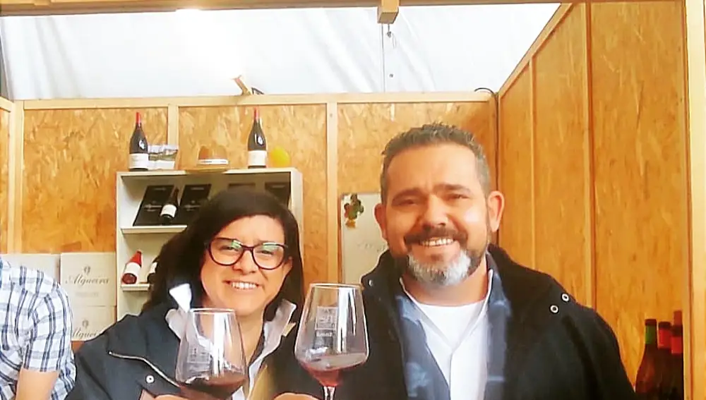María Eugenia, en la feria del vino de Amandi, en Sober (Lugo) junto a su socio, y marido, Roberto y brindando con vino de la tierra.