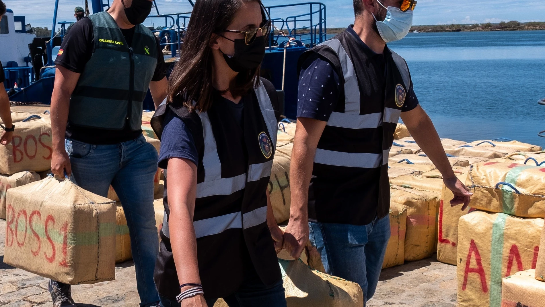 Agentes de la Guardia Civil de Huelva, junto al Servicio de Aduanas y la Policía Judiciaria de Portugal, transportan en el Muelle de Levante del Puerto de Huelva los fardos incautados en el operativo desarrollado contra el narcotráfico a 100 millas de la costa onubense.