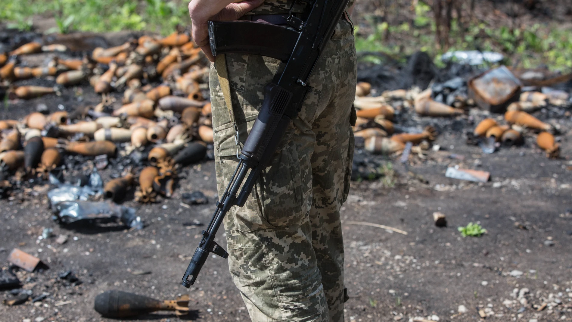 Fotografía tomada el 22 de mayo 2022, de un soldado ucraniano que observa minas terrestres desarmadas en Mala Rohan, una de las aldeas ucranianas donde aún se escuchan explosiones