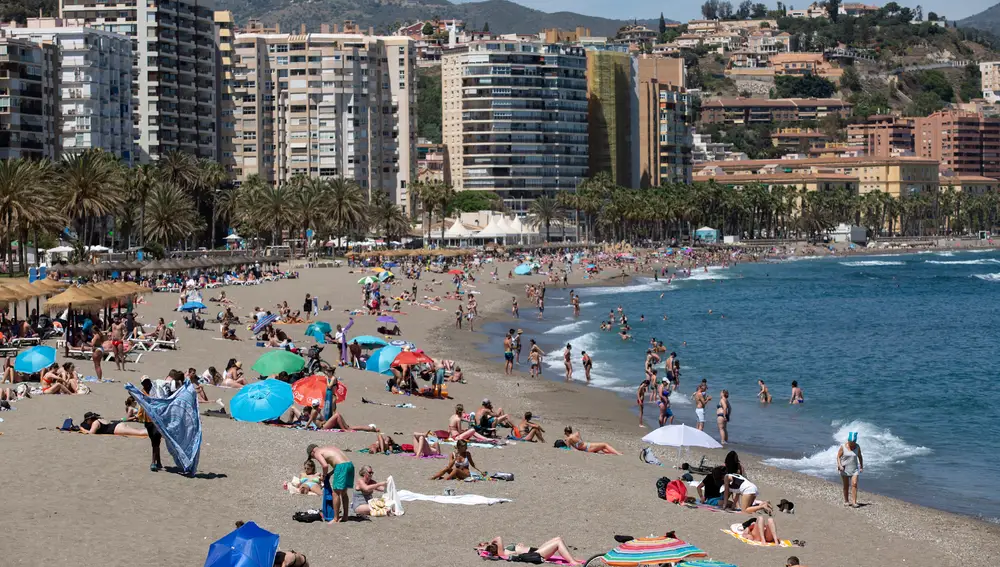 Numerosas personas disfrutan de un día de playa en La Malagueta de la capital malagueña. EFE/Daniel Pérez