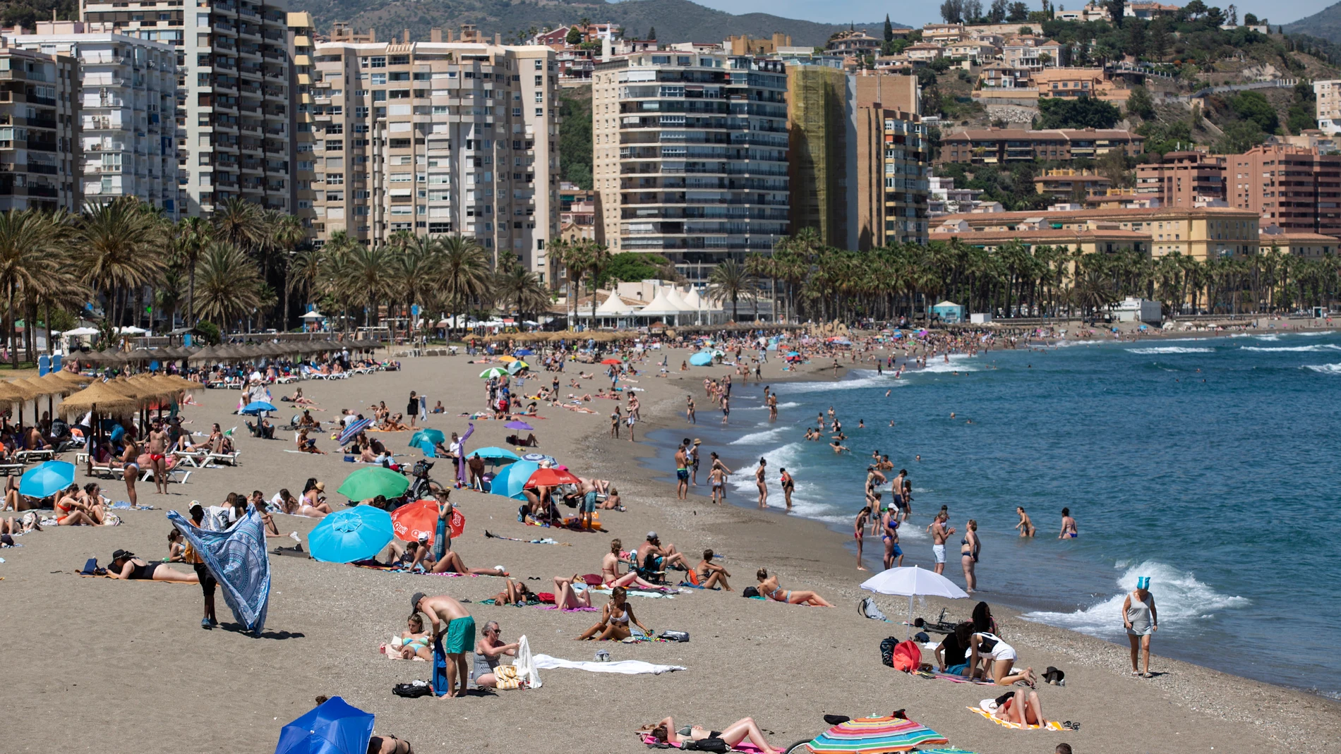 Numerosas personas disfrutan de un día de playa en La Malagueta de la capital malagueña. EFE/Daniel Pérez