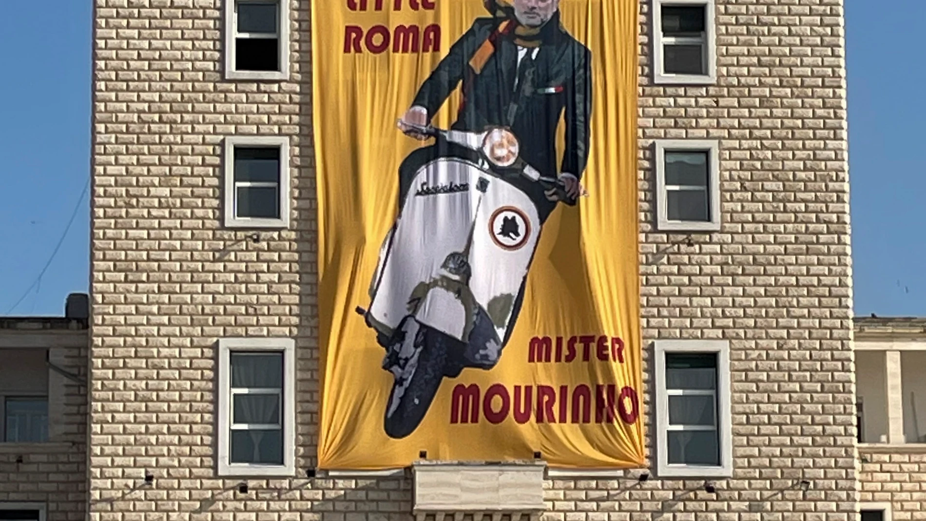 Cartel con los colores amarillo y rojo del club de fútbol de AS Roma dedicado a Mourinho, que está colgado en la fachada de la universidad Politécnica de Tirana