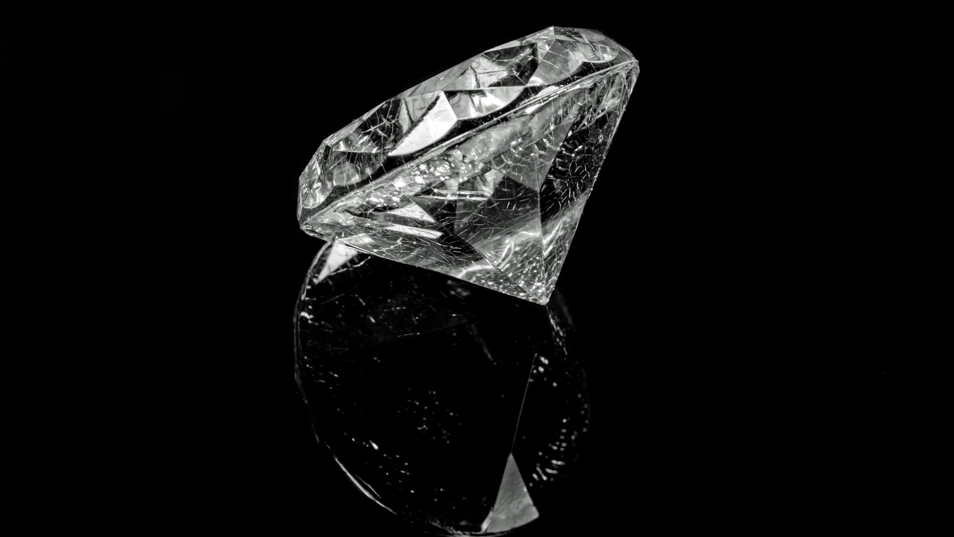 Un diamante transparente inclinado sobre fondo negro