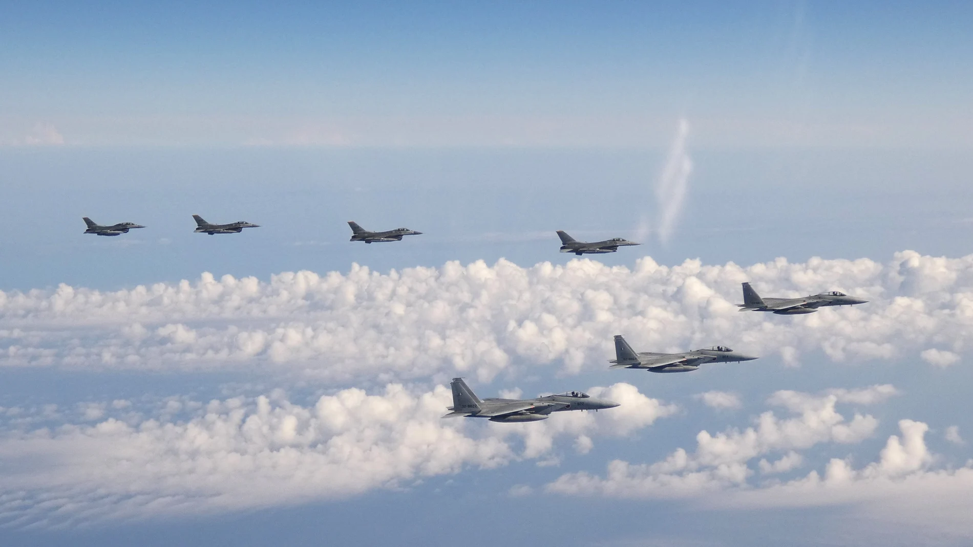 Tres aviones de guerra F-15 de la Fuerza de Autodefensa de Japón, y cuatro cazas F-16 de las Fuerzas Armadas de Estados Unidos vuelan sobre el Mar de Japón en mayo de 2022