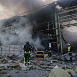 Los bomberos junto a un edificio destruido por un bombardeo ruso en Bakhmut