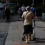 Imagen de una mujer mayor andando por una calle de Madrid