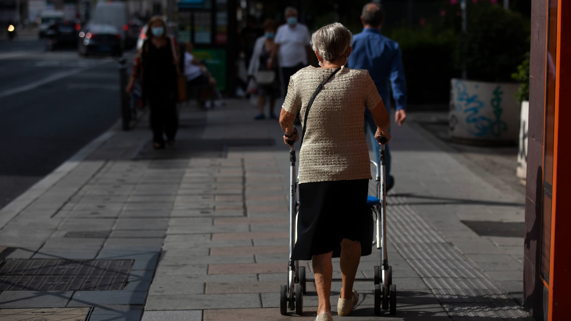 Imagen de una mujer mayor andando por una calle de Madrid