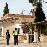 Miembros de la Policía Nacional vigilan la entrada a la vivienda donde una mujer de 50 años ha sido apuñalada de muerte esta madrugada, presuntamente a manos de su pareja, en Benajarafe (Málaga). EFE/Daniel Pérez