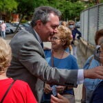 El secretario general del PSOE de Andalucía y candidato a la Presidencia de la Junta, Juan Espadas (c), conversa con los vecinos de Sevilla. EFE/Julio Muñoz