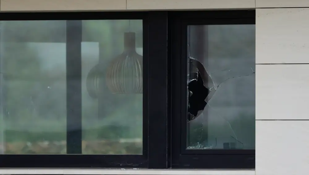 Cristales rotos en la ventana por la que han accedido los servicios de emergencia a la casa del concello coruñés de Carballo