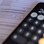 Una calculadora y una escritura de compraventa de una hipoteca