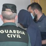 Dos agentes llevan al hombre detenido por haber agredido supuestamente a su pareja, para ser puesto en disposición judicial, en el Juzgado de Instrucción número 1, a 1 de junio de 2022, en Carballo, A Coruña, Galicia (España)