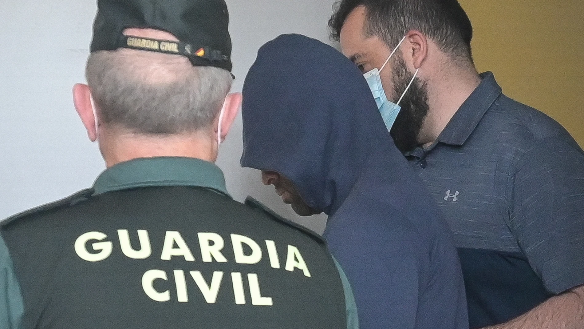 Dos agentes llevan al hombre detenido por haber agredido supuestamente a su pareja, para ser puesto en disposición judicial, en el Juzgado de Instrucción número 1, a 1 de junio de 2022, en Carballo, A Coruña, Galicia (España)