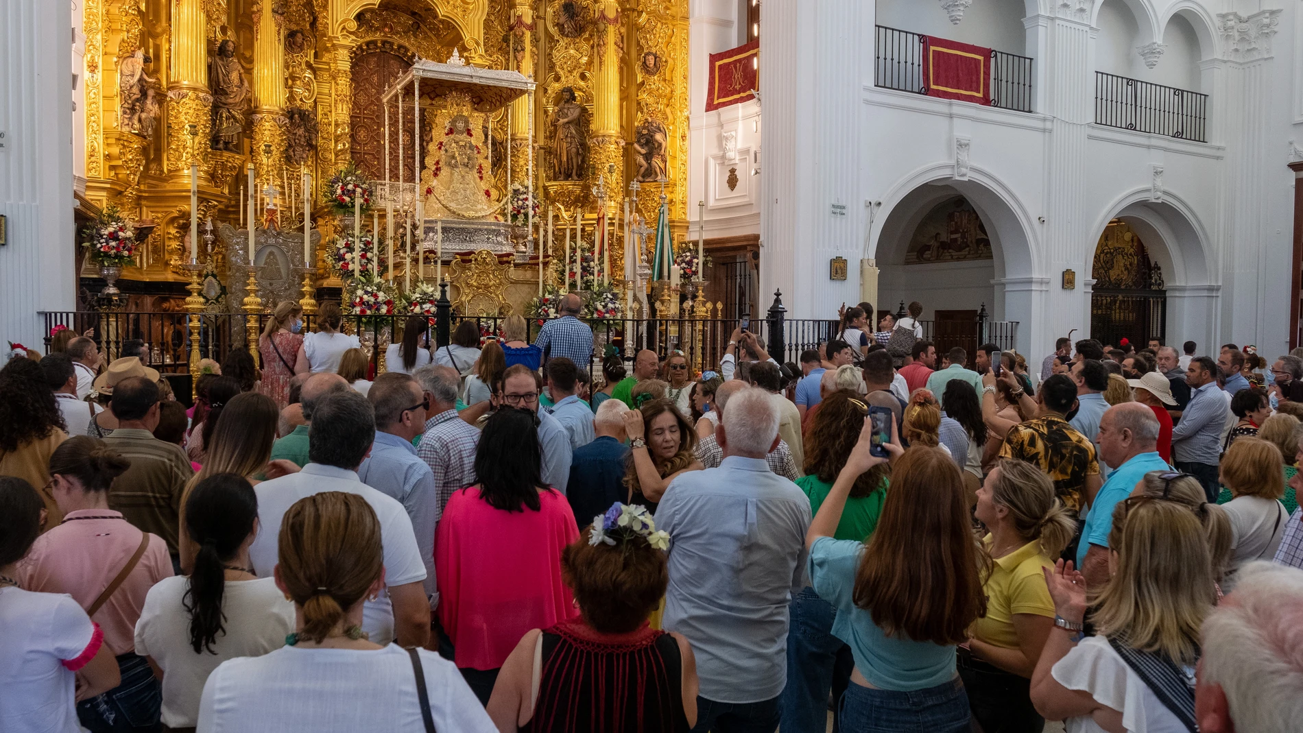 Cientos de personas rezan ante la imagen de la Virgen del Rocío en el Santuario ubicado en la aldea almonteña de El Rocío (Huelva)