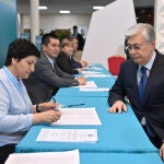 El presidente de Kazajistán, Kasim-Yomart Tokáyev (d), en la mesa electoral antes de votar.