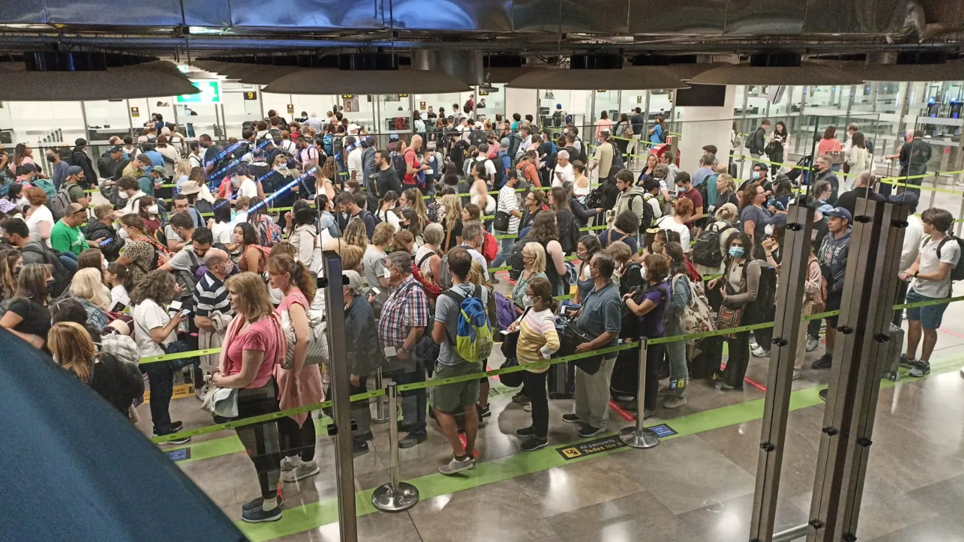 Decenas de pasajeros hacen cola hoy en el control de pasaportes del aeropuerto de Madrid-Barajas