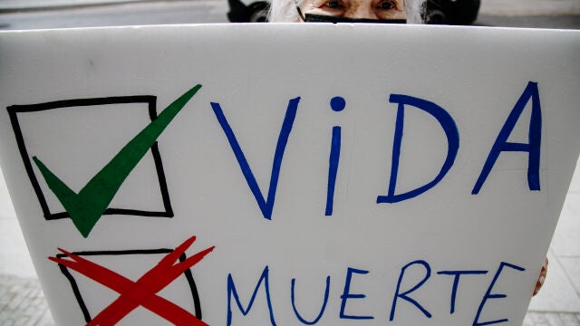 Una persona sujeta una pancarta durante una acción frente al ministerio contra la ley del aborto en Madrid (España).