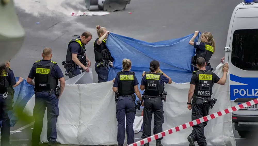 Anges de policía cubren el cadáver de una de las víctimas del atropello de Berlín