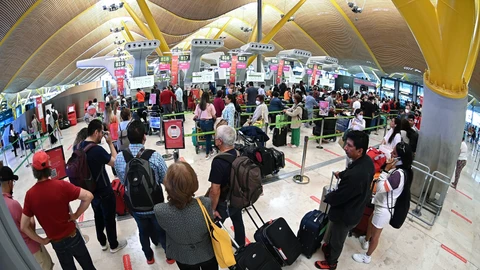 Decenas de personas hacen cola para facturar el equipaje en el Aeropuerto de Barajas de Madrid