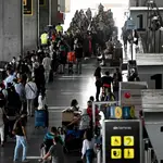 Decenas de personas hacen cola este miércoles para facturar el equipaje en el Aeropuerto de Barajas de Madrid