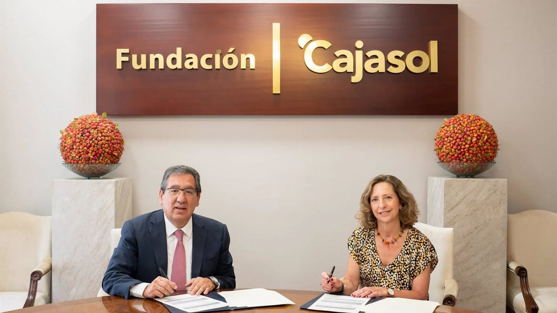 El presidente de la Fundación Cajasol, Antonio Pulido, y la presidenta de la Asociación Autismo de Sevilla, Mercedes Molina, firman un acuerdo de colaboración