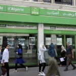 Ciudadanos argelinos paseando por la puerta del Banco Nacional de Argelia.