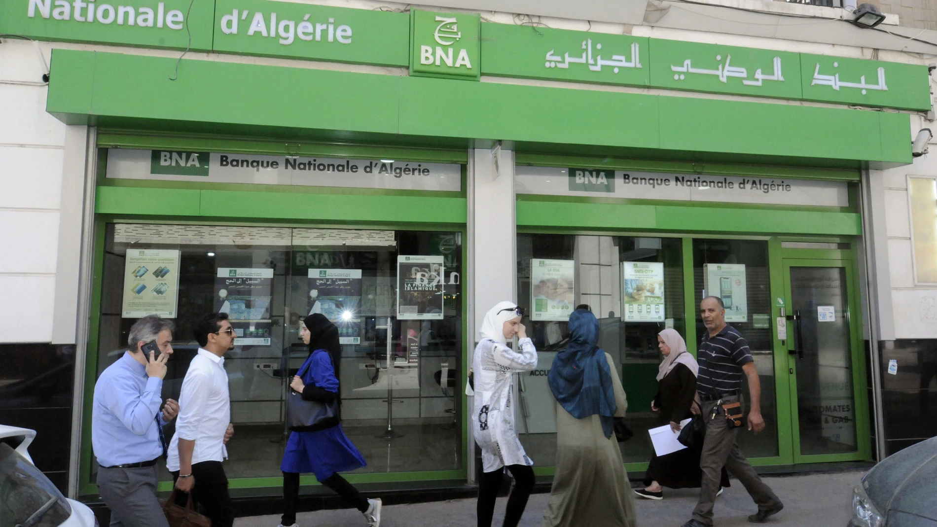 Ciudadanos argelinos paseando por la puerta del Banco Nacional de Argelia.