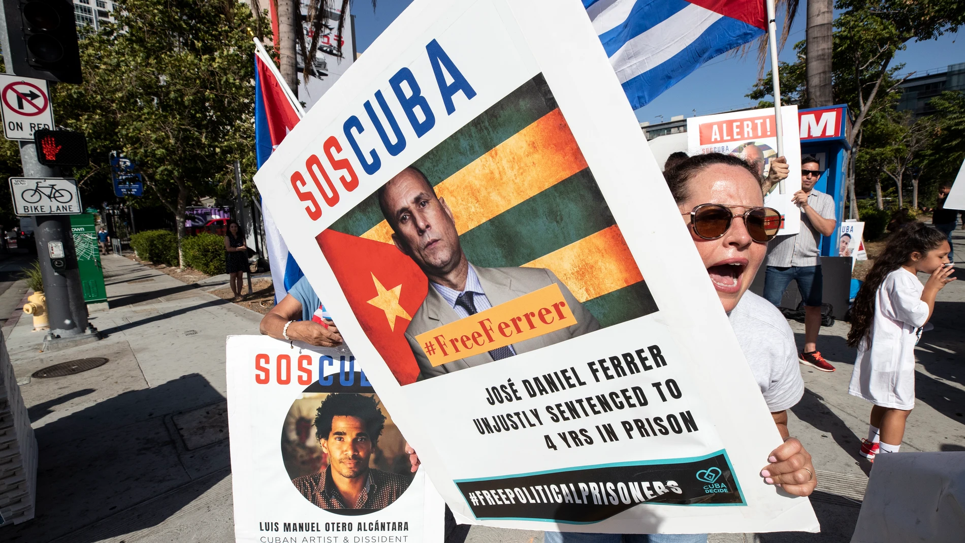 Los Angeles (United States), 08/06/2022.- A protester holds a poster reading 'SOS Cuba' and displays the portrait of a Cuban allegedly wrongfully imprisonned by the regime, as they gather in front of the Microsoft Theater, where leaders and heads of delegations arrive for the inaugural ceremony of the 2022 Summit of the Americas, in Los Angeles, California, USA, 08 June 2022. (Protestas, Estados Unidos) EFE/EPA/ETIENNE LAURENT