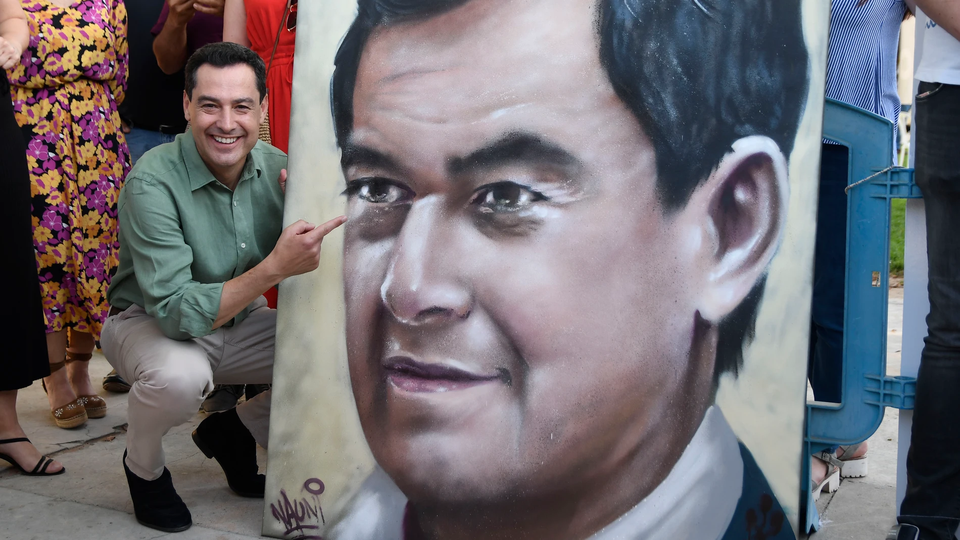 El presidente del PP de Andalucía y candidato a la reelección como presidente de la Junta, Juanma Moreno, posa junto a un grafiti con su rostro durante un mitin del Partido Popular en El Ejido (Almería). EFE/Carlos Barba
