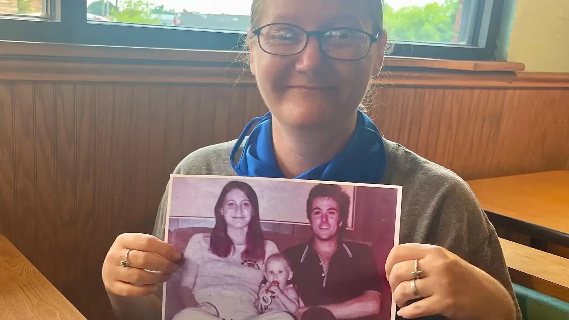 Holly, de 42 años, con una foto de ella y sus padres, asesinados hace más de 40 años en Texas