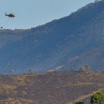 Un helicóptero sobrevuela la zona afectada por el incendio