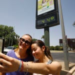 Varios turistas se fotografían junto a un termómetro que marca 44 grados, este domingo en Córdoba