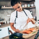 Imagen de mujer cocinando grabando un vídeo.