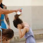 Varias madres del colegio Mediterráneo de Córdoba refrescan a sus hijos con botellas de agua