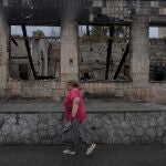 Una mujer frente a una casa destrozada en Makariv