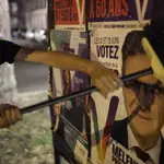 Un simpatizante de Jean Luc Mélenchon pega un cartel electoral del líder izquierdista en Estrasburgo
