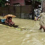 18 June 2022, India, Guwahati: A man pulls a raft with two children on the flood waters that have submerged a village in the Nalbari district. Photo: Dasarath Deka/ZUMA Press Wire/dpa Dasarath Deka/ZUMA Press Wire/dp / DPA 18/06/2022 ONLY FOR USE IN SPAIN