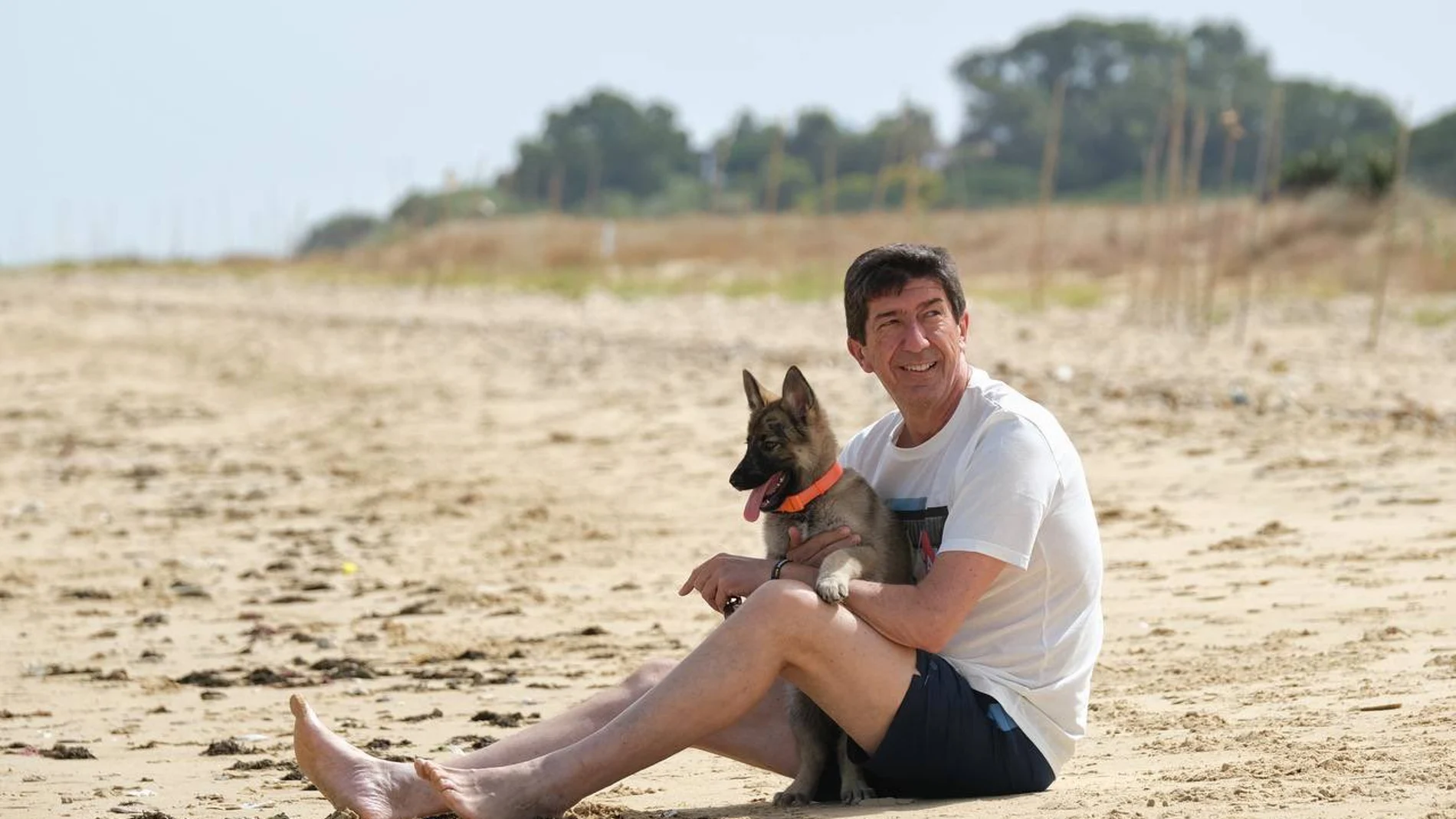 Juan Marín y su perra Ira, en la playa de La Jara, en Sanlúcar de Barrameda