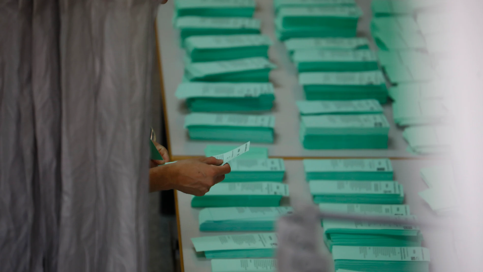 Una persona elige papeleta de voto en un colegio andaluz. EFE/Salas