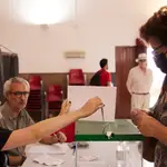 La presidenta, de una mesa electoral, mete un voto en la urna durante el día de las eleccione