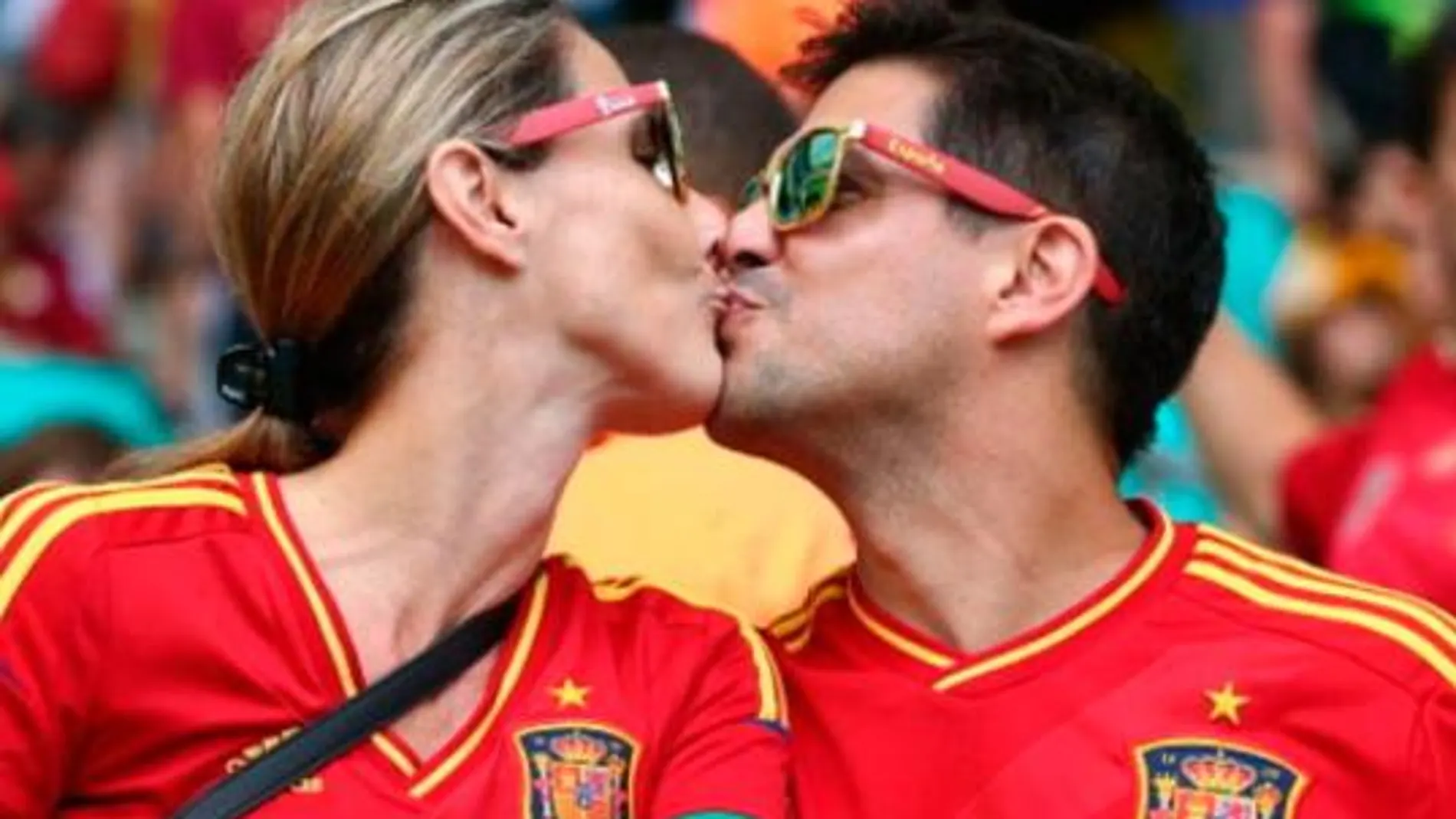 Una pareja de aficionados se besa en la grada durante un encuentro