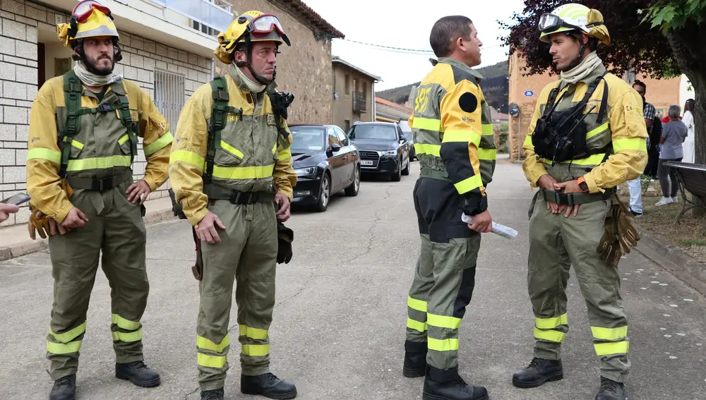 El bombero forestal de la Brigada de Refuerzo de Incendios Forestales (BRIF) Jesús Alonso (d) habla con varios compañeros, este miércoles en Otero de Bodas, Zamora