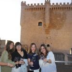 Un grupo de jóvenes brinda con vino de Ribera de Duero en el castillo de Peñafiel (Valladolid)